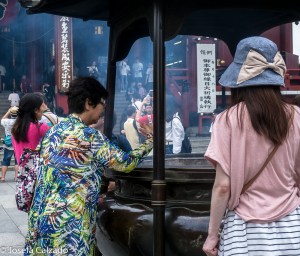 Detalle turista llevándose el humo hacia la cabeza